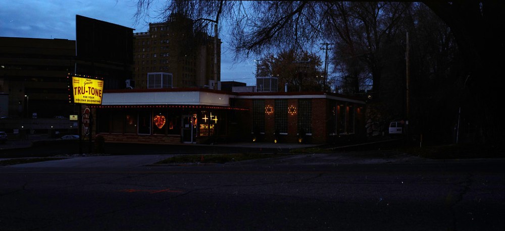 An illuminated restaurant named Tru-Tone at dusk, featuring a vintage-style sign and warm lights in the windows.